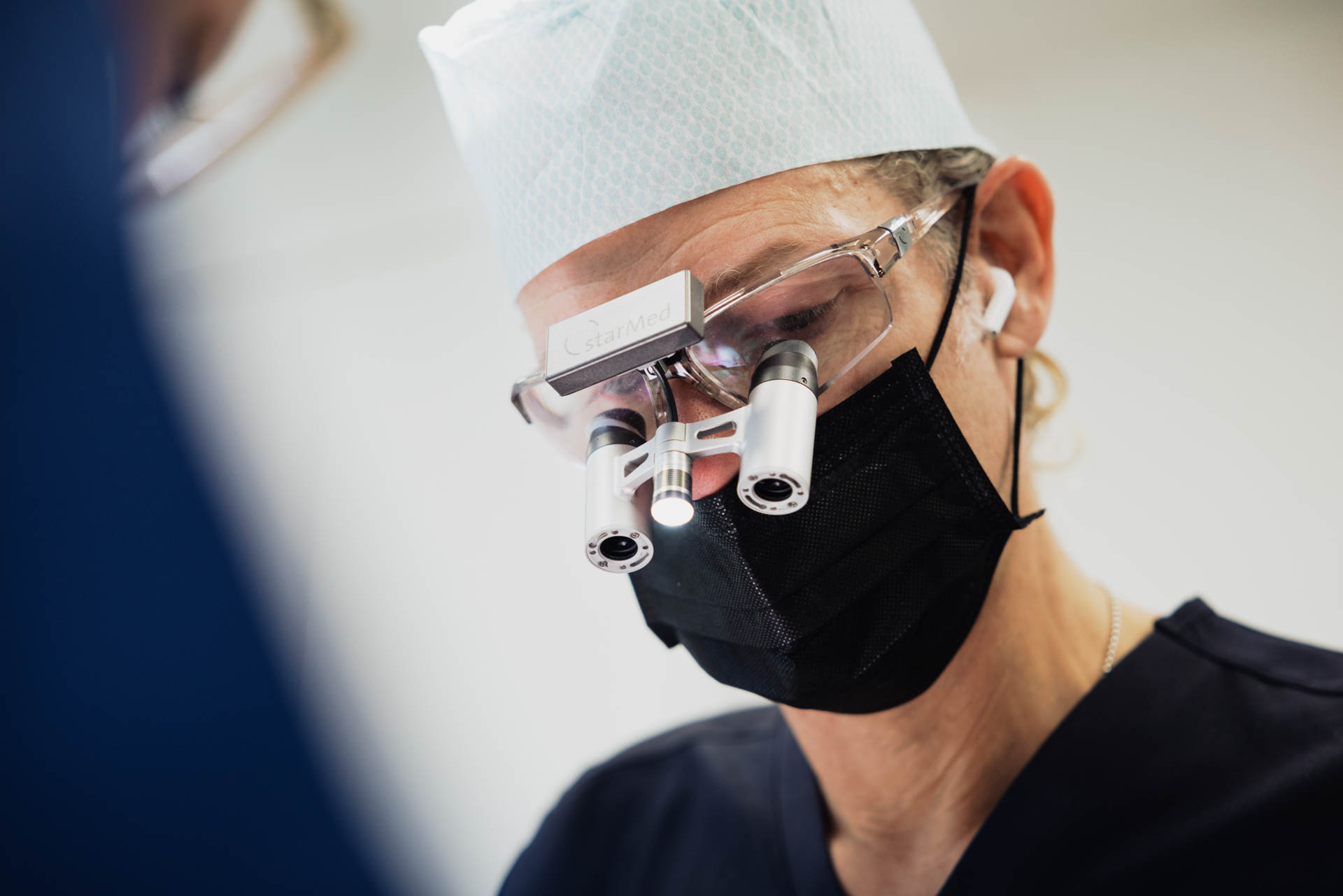 Behandler mit chirurgischer Lupenbrille bei einer Behandlung in der Stadtwald Klinik