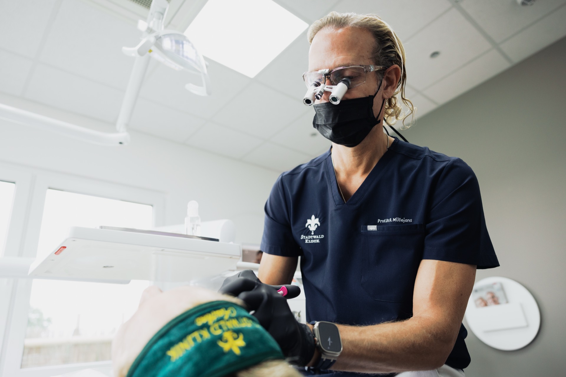 Behandelnder Arzt mit Lupenbrille bei der Lippenbehandlung in der Stadtwald Klinik
