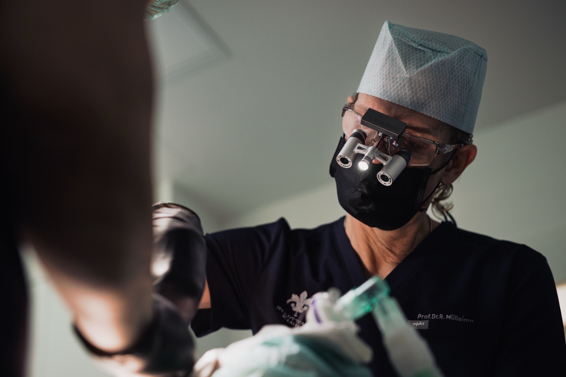 Behandler bei einer Wurzelbehandlung mit Lupenbrille in der Stadtwald Klinik